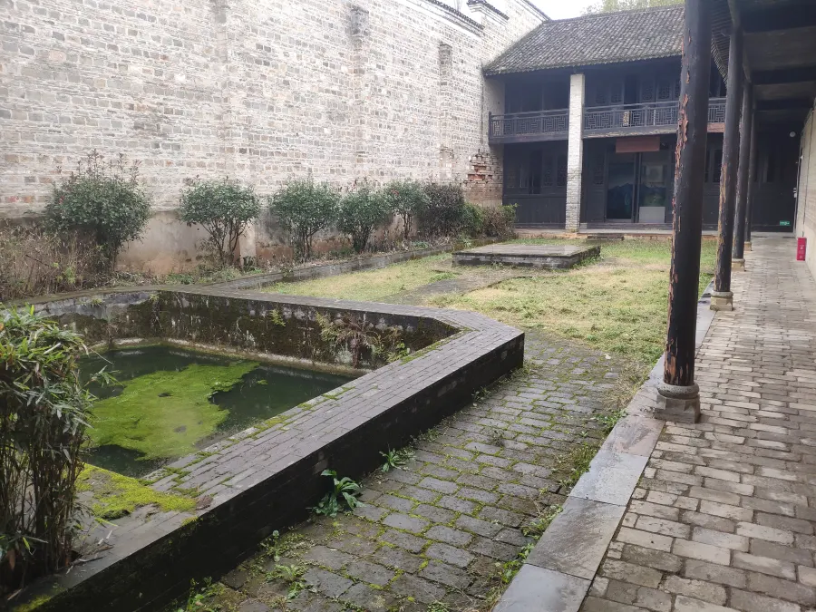 濬宅的花园，庇护在高大的围墙之下。前方建筑为“胡耀邦同志革命生涯第一站”展室